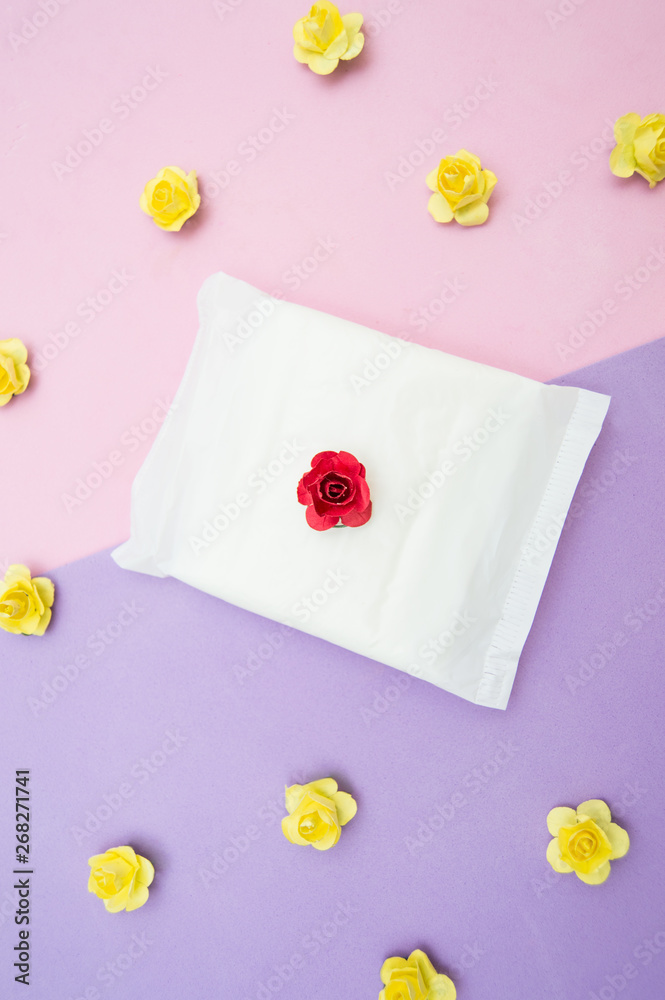 women's pads on pink background. Menstrual cycle, concept. Yellow flowers. women's pads on pink background. Menstrual cycle, concept. Yellow flowers.