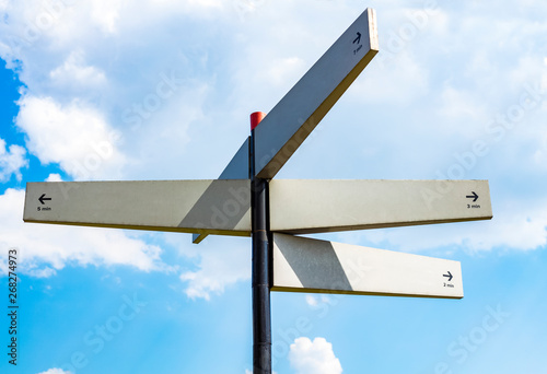 Blank signpost with many directions against blue sky in sunny day. Mockup. copy space