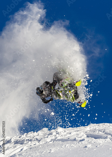 a guy on a snowmobile in a jump makes a pipe with a trace of snow. beautiful flight of a snowmobile after a jump. bright snowmobile and suit without brands. extra high quality