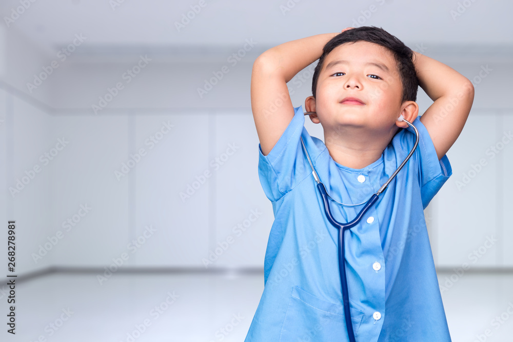 Smiling Asian kid in blue medical uniform holding stethoscope looking at camera, healthy concept. Smiling Asian kid in blue medical uniform holding stethoscope looking at camera, healthy concept.