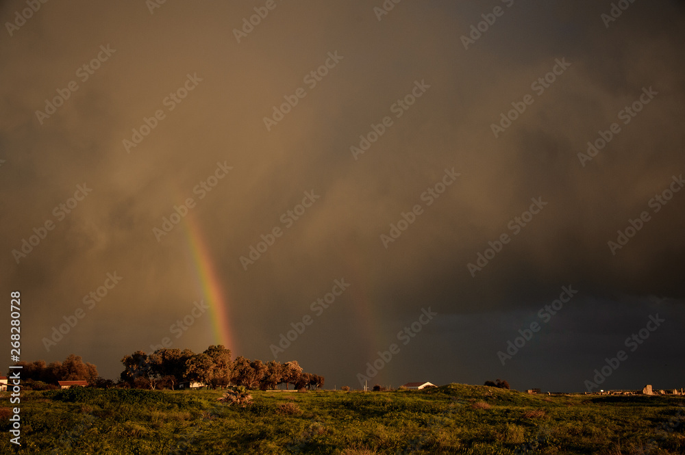Small village houses under the sky with a rainbow