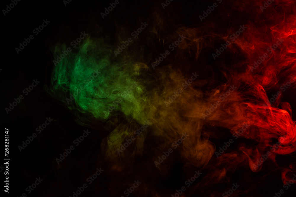 Beautiful horizontal column of smoke in the neon bright light of red, green, yellow and orange on a black background exhaled out of the vape. Nice pattern for printing and backdrop of colored waves. Beautiful horizontal column of smoke in the neon bright light of red, green, yellow and orange on a black background exhaled out of the vape. Nice pattern for printing and backdrop of colored waves.