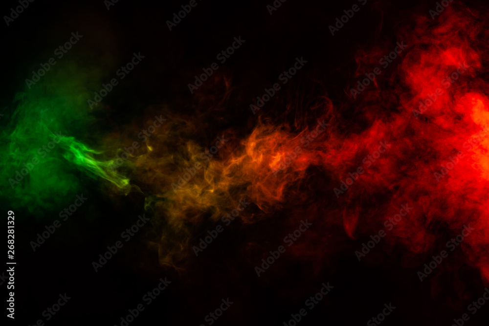 Beautiful horizontal column of smoke in the neon bright light of red, green, yellow and orange on a black background exhaled out of the vape. Nice pattern for printing and backdrop of colored waves.