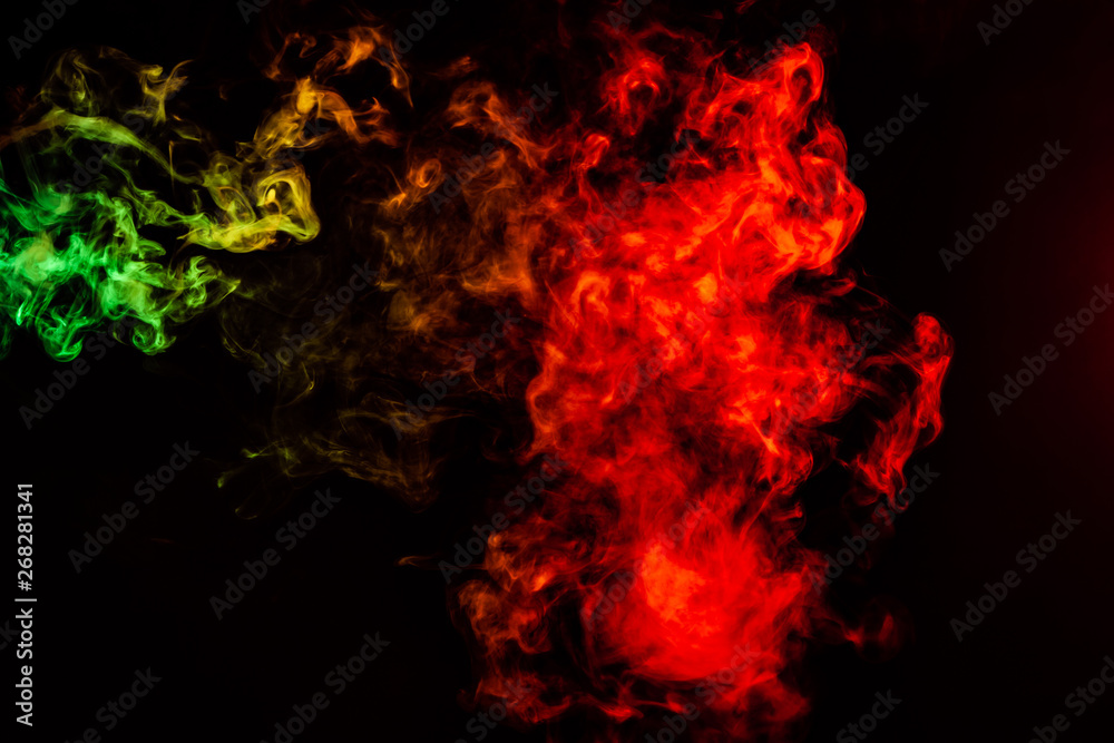 Beautiful horizontal column of smoke in the neon bright light of red, green, yellow and orange on a black background exhaled out of the vape. Nice pattern for printing and backdrop of colored waves.