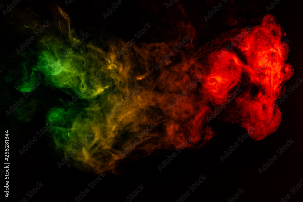 Fototapeta premium Beautiful horizontal column of smoke in the neon bright light of red, green, yellow and orange on a black background exhaled out of the vape. Nice pattern for printing and backdrop of colored waves.