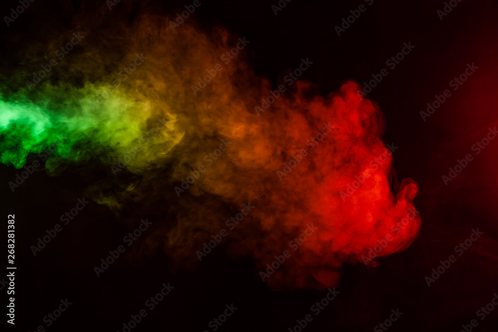 Fototapeta premium Beautiful horizontal column of smoke in the neon bright light of red, green, yellow and orange on a black background exhaled out of the vape. Nice pattern for printing and backdrop of colored waves.