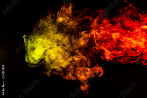 Beautiful horizontal column of smoke in the neon bright light of red, green, yellow and orange on a black background exhaled out of the vape. Nice pattern for printing and backdrop of colored waves. © Aleksandr Kondratov