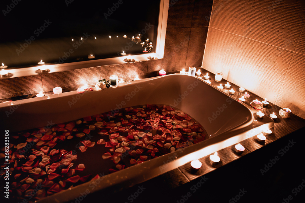 a bath filled with rose petals by candlelight is romantic Stock Photo |  Adobe Stock