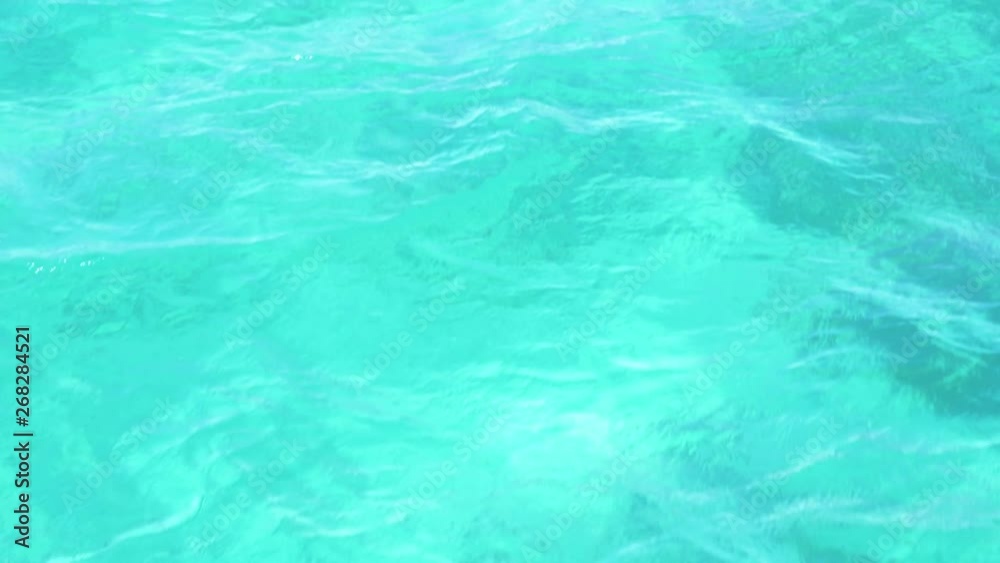Turquoise water texture as boat cruises through clear water (slow motion) Turquoise water texture as boat cruises through clear water (slow motion)