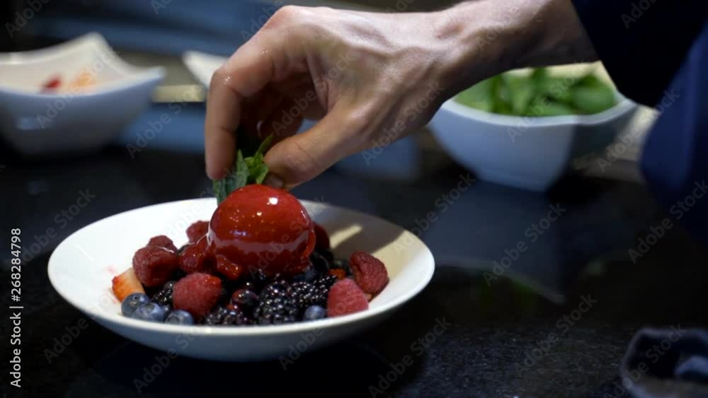 Preparing an ice cream dessert, putting the mint on top of the dessert Preparing an ice cream dessert, putting the mint on top of the dessert