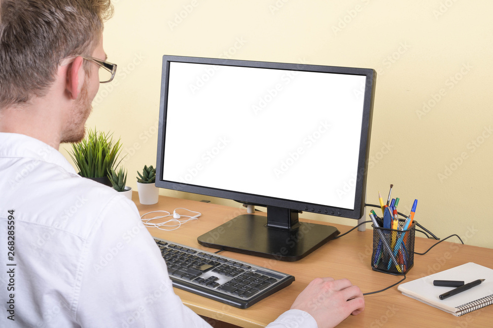 Office worker at the workplace at the computer with copy space on the monitor.Looking at Something on the Computer Screen Office worker at the workplace at the computer with copy space on the monitor.Looking at Something on the Computer Screen