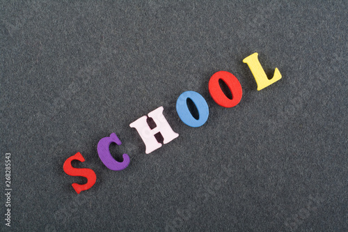 SCHOOL word on black board background composed from colorful abc alphabet block wooden letters, copy space for ad text. Learning english concept.