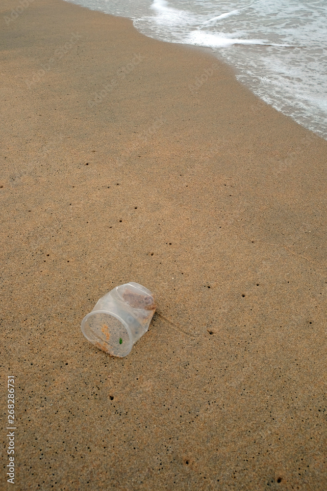 Plastic glass is on the sand beach, Water pollution Plastic glass is on the sand beach, Water pollution