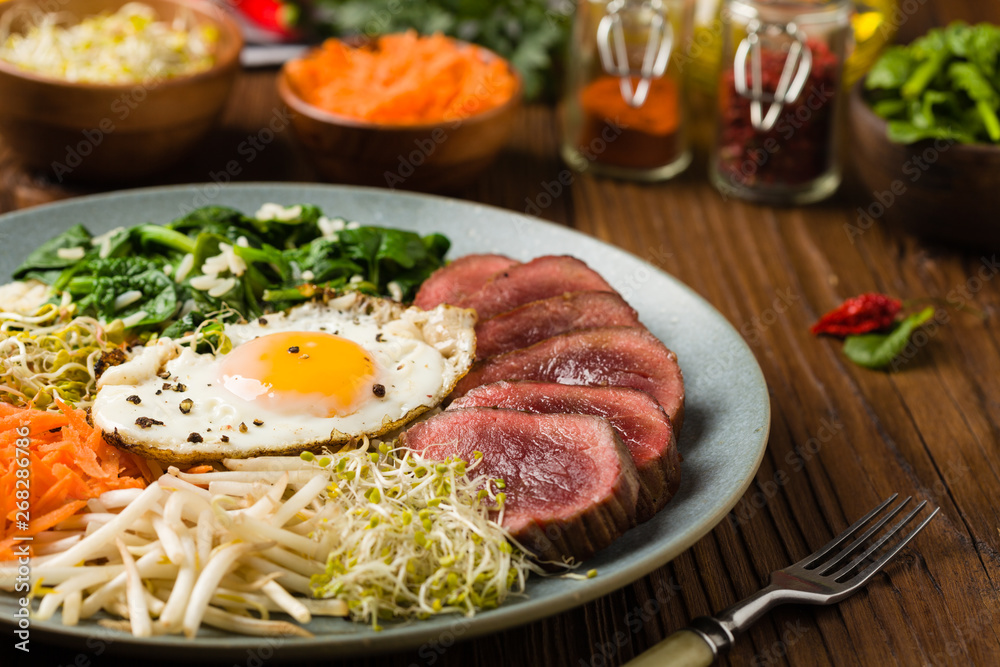 Korean beef with sprouts, spinach and fried egg. Korean beef with sprouts, spinach and fried egg.