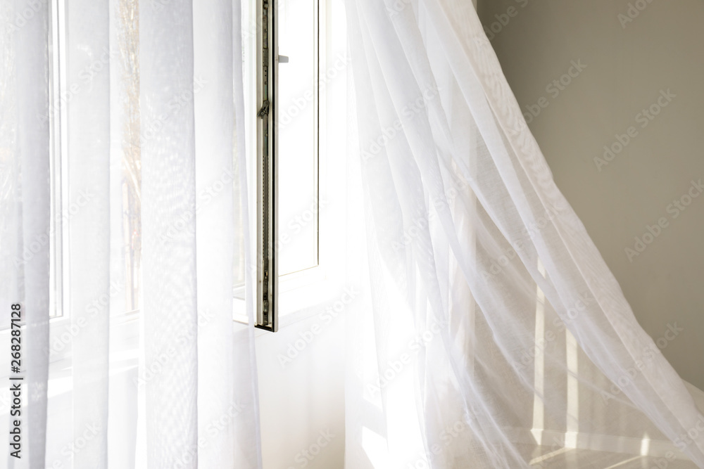 Open window with light curtains in room