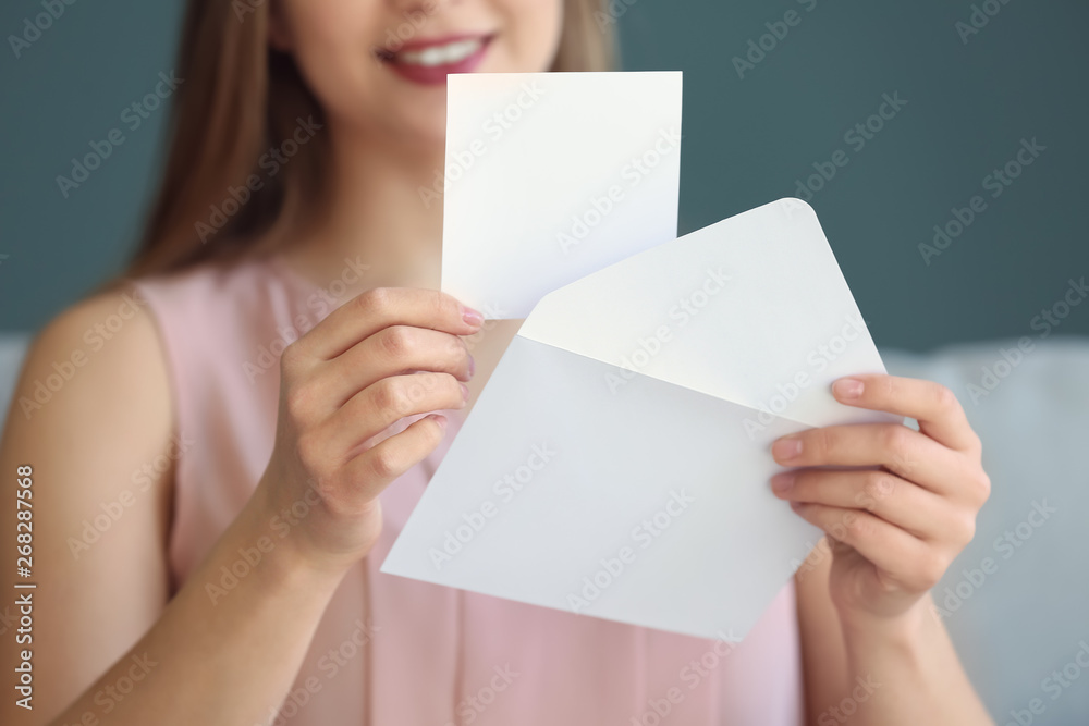 Young woman opening envelope with invitation at home, closeup Young woman opening envelope with invitation at home, closeup