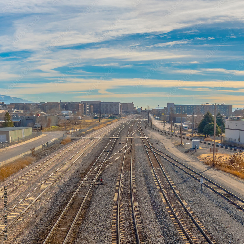 Clear Square Railroad tracks and roads with mountain and vibrant cloudy blue sky background Clear Square Railroad tracks and roads with mountain and vibrant cloudy blue sky background