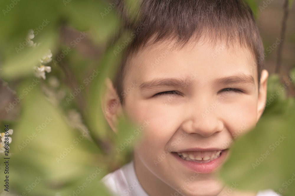 portrait of a laughing boy with brown eyes in the garden portrait of a laughing boy with brown eyes in the garden