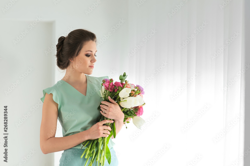 Beautiful young woman with bouquet of flowers at home Beautiful young woman with bouquet of flowers at home