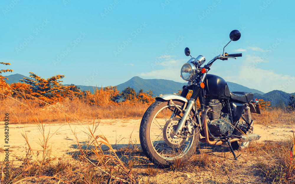 Obraz premium Aged motorbike under sky with digital color picture photo effect