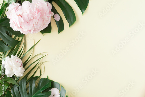 Creative layout and background made of tropical palm leaves and pink pastel f...