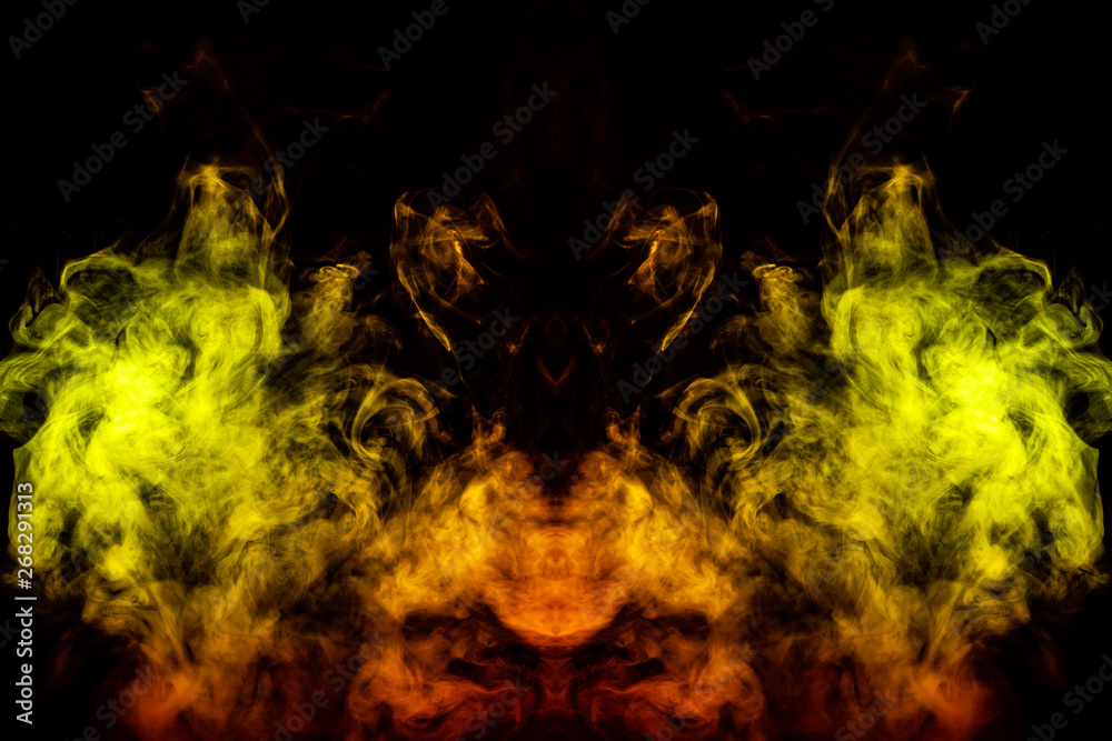 Smoke of different green, yellow, orange and red colors in the form of horror in the shape of the head, face and eye with wings on a black isolated background. Soul and ghost in mystical symbol
