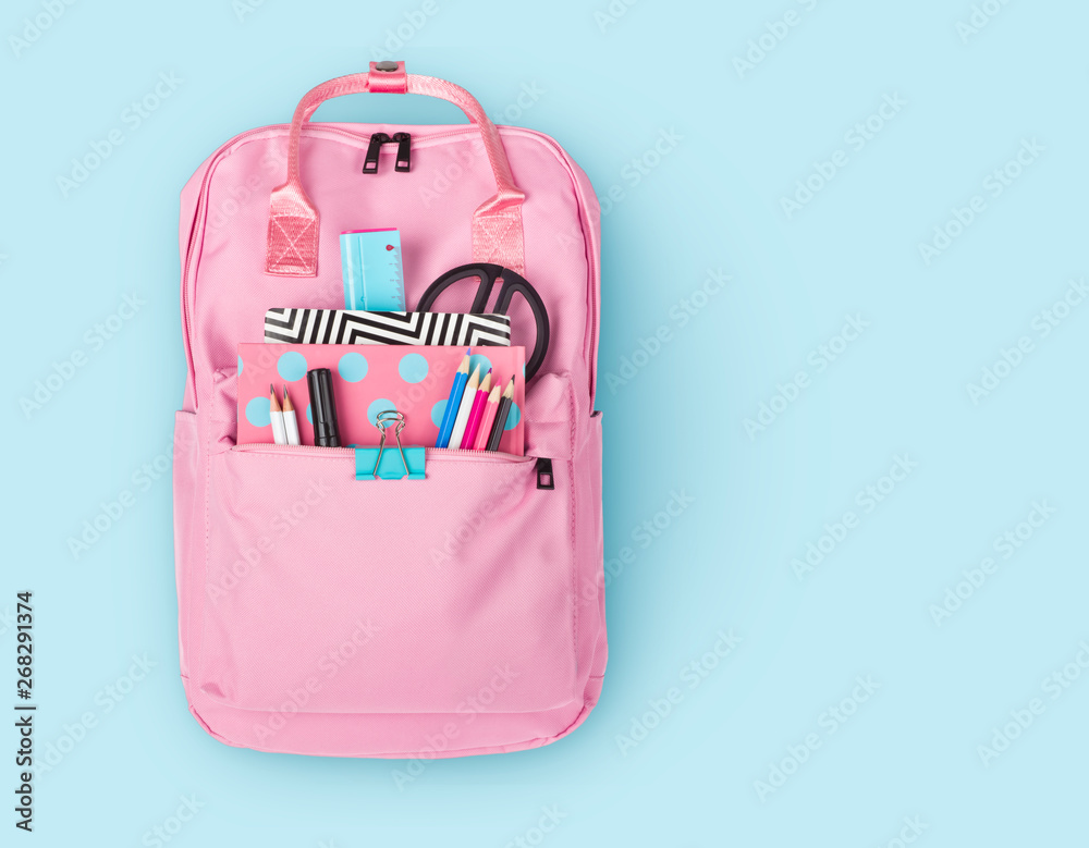 Children backpack with various school stationery isolated on blue background - obrazy, fototapety, plakaty 