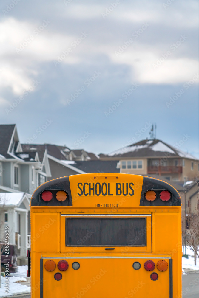 Yellow school bus with rectangular window and several signal lights at the rear