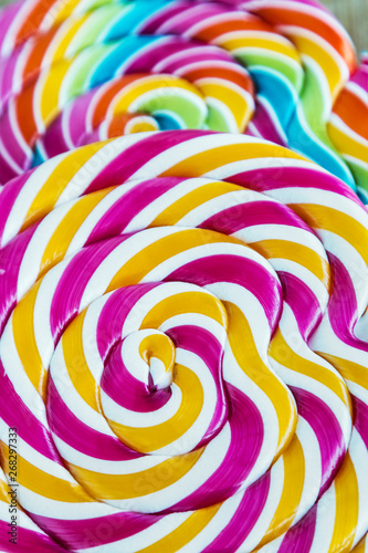 striped spiral multi-color Lollipop closeup. sweets multicolour
