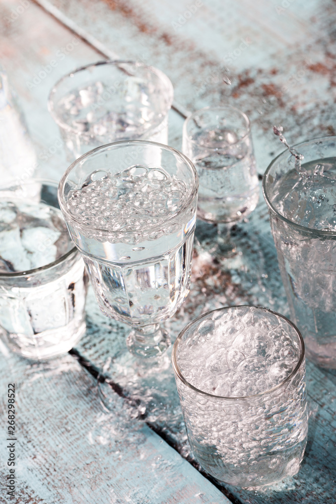 Glasses full of water for the refreshment on a hot summer day. Rain water on a table Glasses full of water for the refreshment on a hot summer day. Rain water on a table