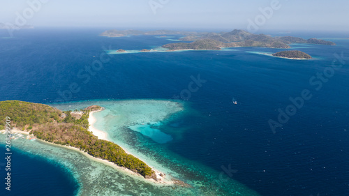 aerial seascape tourists enjoy the tropical beach. tropical island with sand beach, palm trees. Malcapuya, Philippines, Palawan. Tropical landscape with blue lagoon, coral reef
