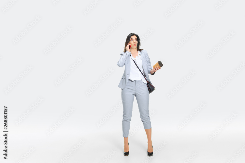 I refuse to understand. Young woman in gray suit is getting shocking news from boss or colleagues. Looking numbed while dropping coffee. Concept of office worker's troubles, business, stress. I refuse to understand. Young woman in gray suit is getting shocking news from boss or colleagues. Looking numbed while dropping coffee. Concept of office worker's troubles, business, stress.