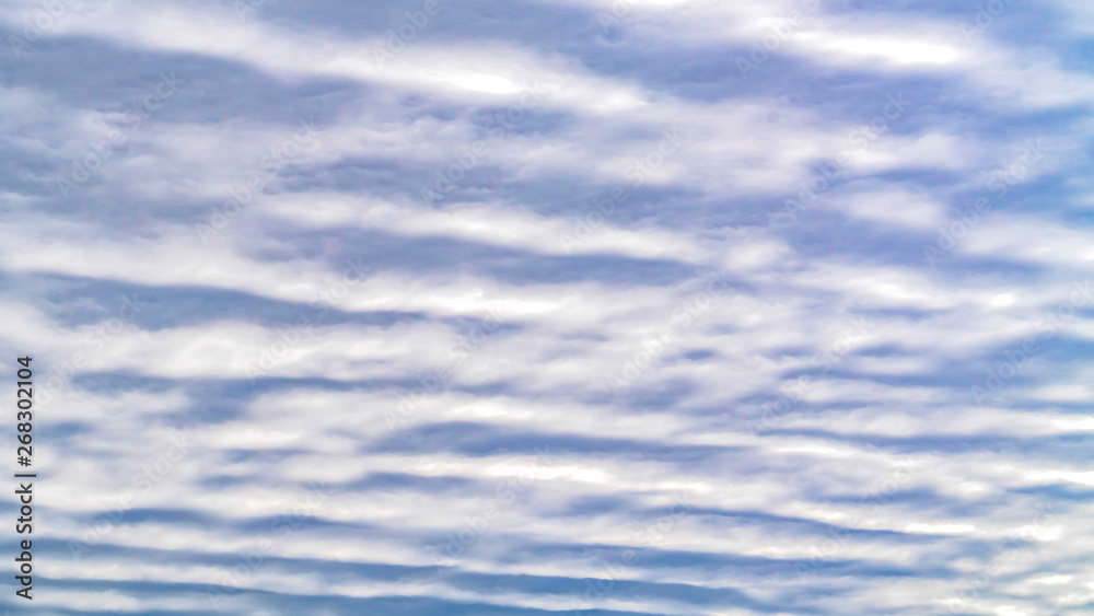 Panorama Defocused view of a boundless blue sky filled with white puffy clouds