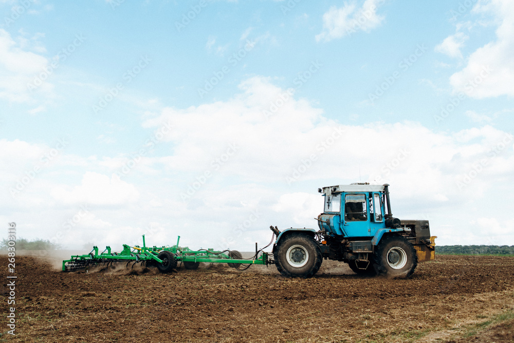 The tractor works in the field. The release of grass with a tractor. Farmer's work The tractor works in the field. The release of grass with a tractor. Farmer's work