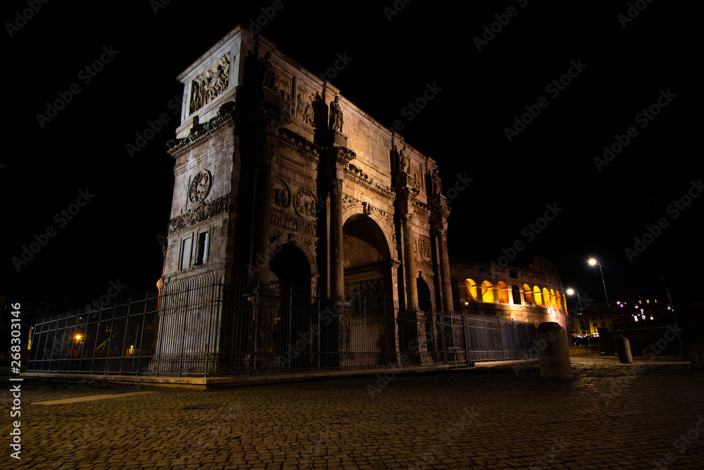 Arch of Constantine with the Colosseum in the background in Rome - Italy