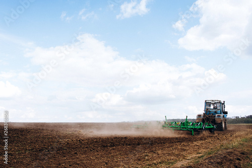 The tractor works in the field. The release of grass with a tractor. Farmer's work