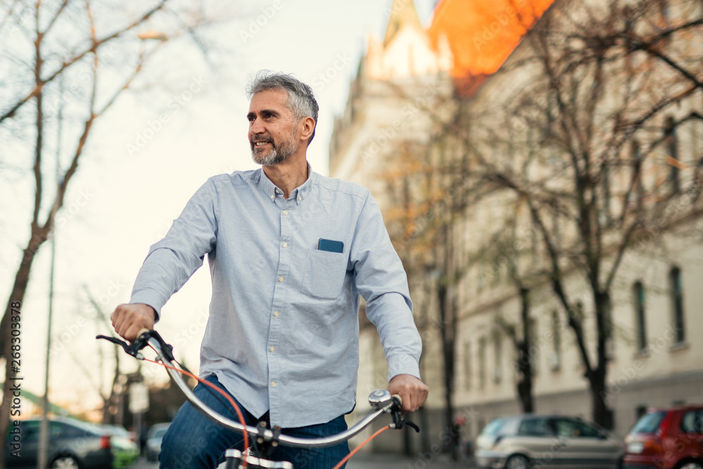 middle aged man riding bike on street middle aged man riding bike on street
