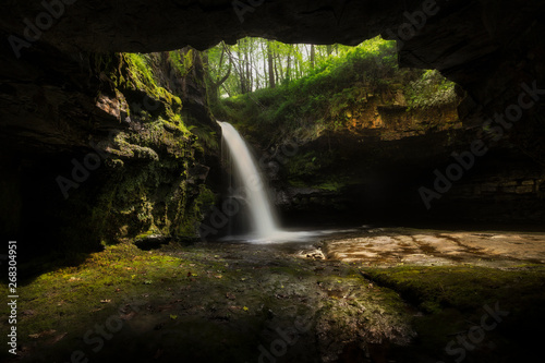 A small cave at the side of Sgwd Ddwli Isaf waterfall in Waterfall Country on the river Neath  near Pontneddfechan in South Wales  UK.