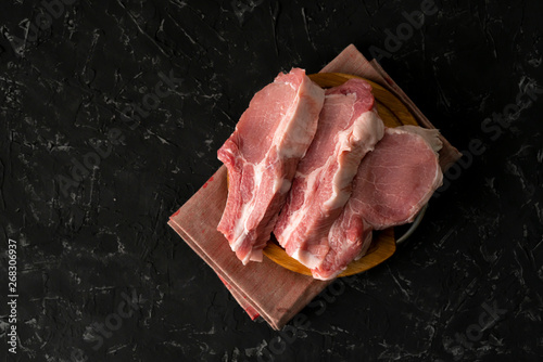 top view of raw meat uncooked slices, cut pork on a wooden board isolateds
