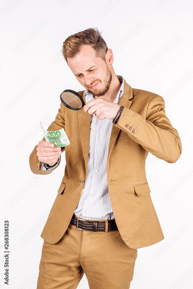 man looking through a magnifying glass on euro bank note. man looking through a magnifying glass on euro bank note.