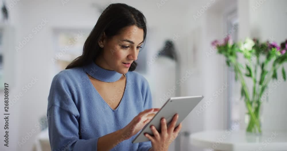 4K Beautiful young Hispanic woman using touchscreen computer at home. Slow motion