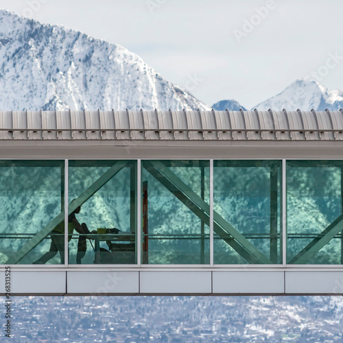 Clear Square Skyway between buildings with a view of snowy mountain and cloudy sky in winter