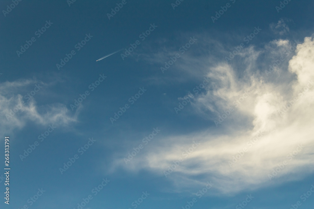 looking up view of commercial airplane against blue sky and clouds looking up view of commercial airplane against blue sky and clouds