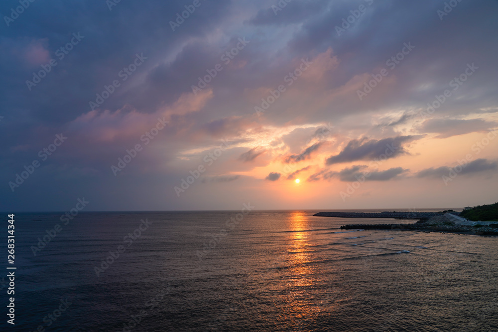 Seascape at Yellow glowing sun setting in the horizon with breakwater. Seascape at Yellow glowing sun setting in the horizon with breakwater.