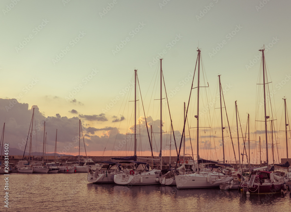 Obraz premium calm harbor scene. boats against sunset. vintage