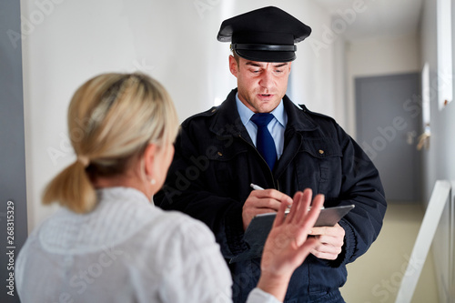 Polizist macht Zeugenbefragung nach Einbruch photo