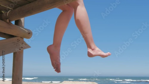 Bare feet of woman sitting and relaxing on seach