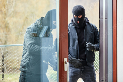 Einbrecher öffnen Terrassentür mit Brecheisen photo