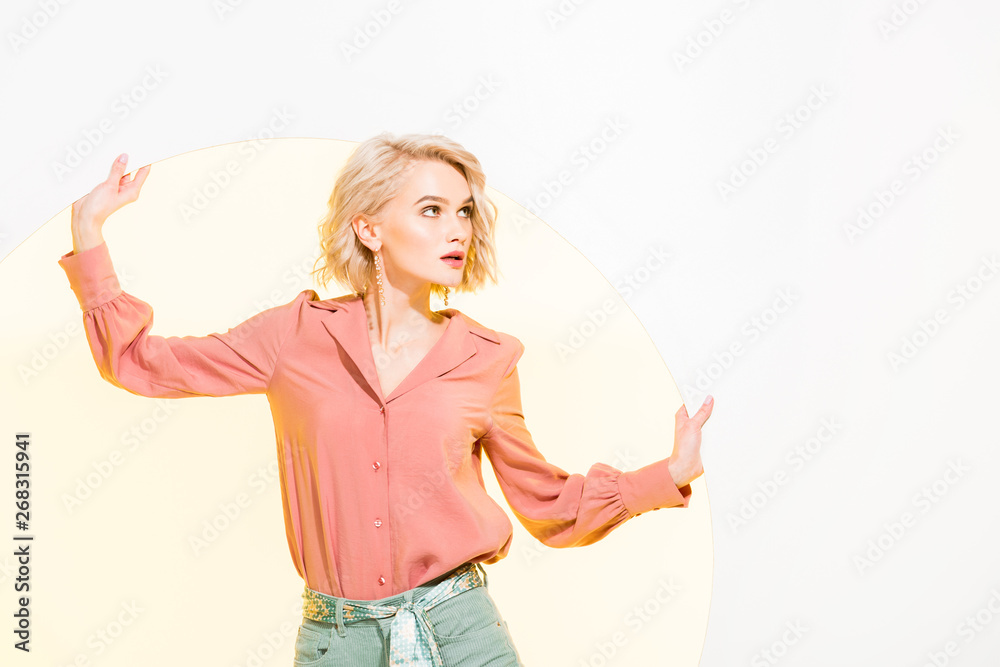 Obraz premium beautiful fashionable girl in colorful clothes posing on white with yellow circle