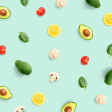 Creative pattern made of avocado, tomato, champignon and lemon on green background. Flat lay. Food concept.